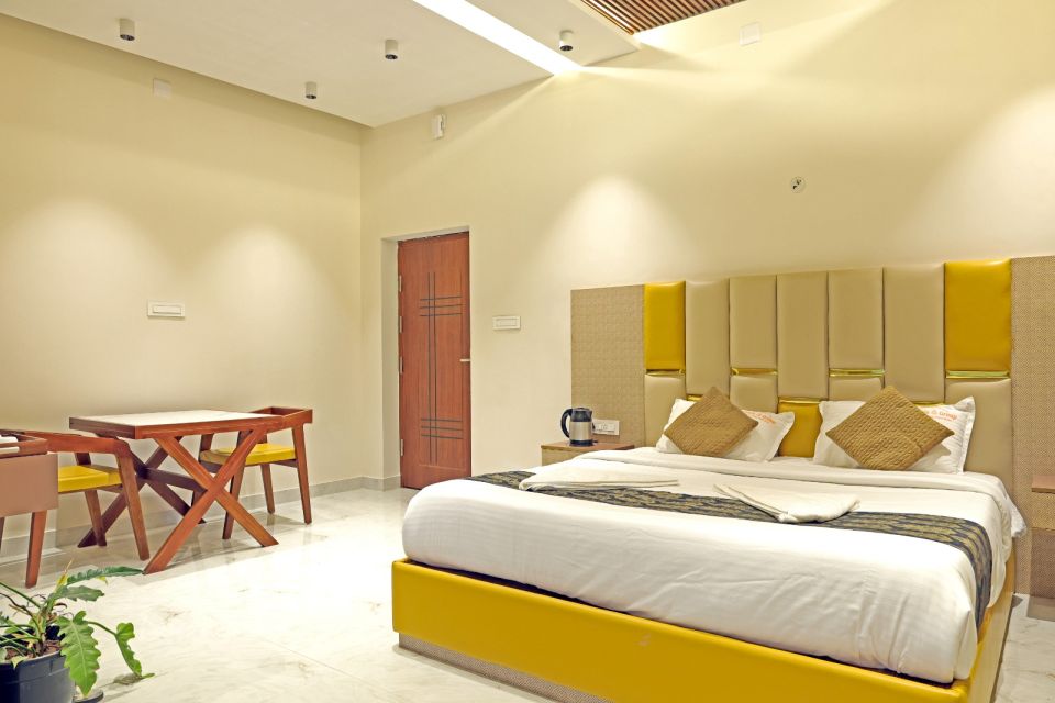 Deluxe room with king-size bed and gold upholstered headboard