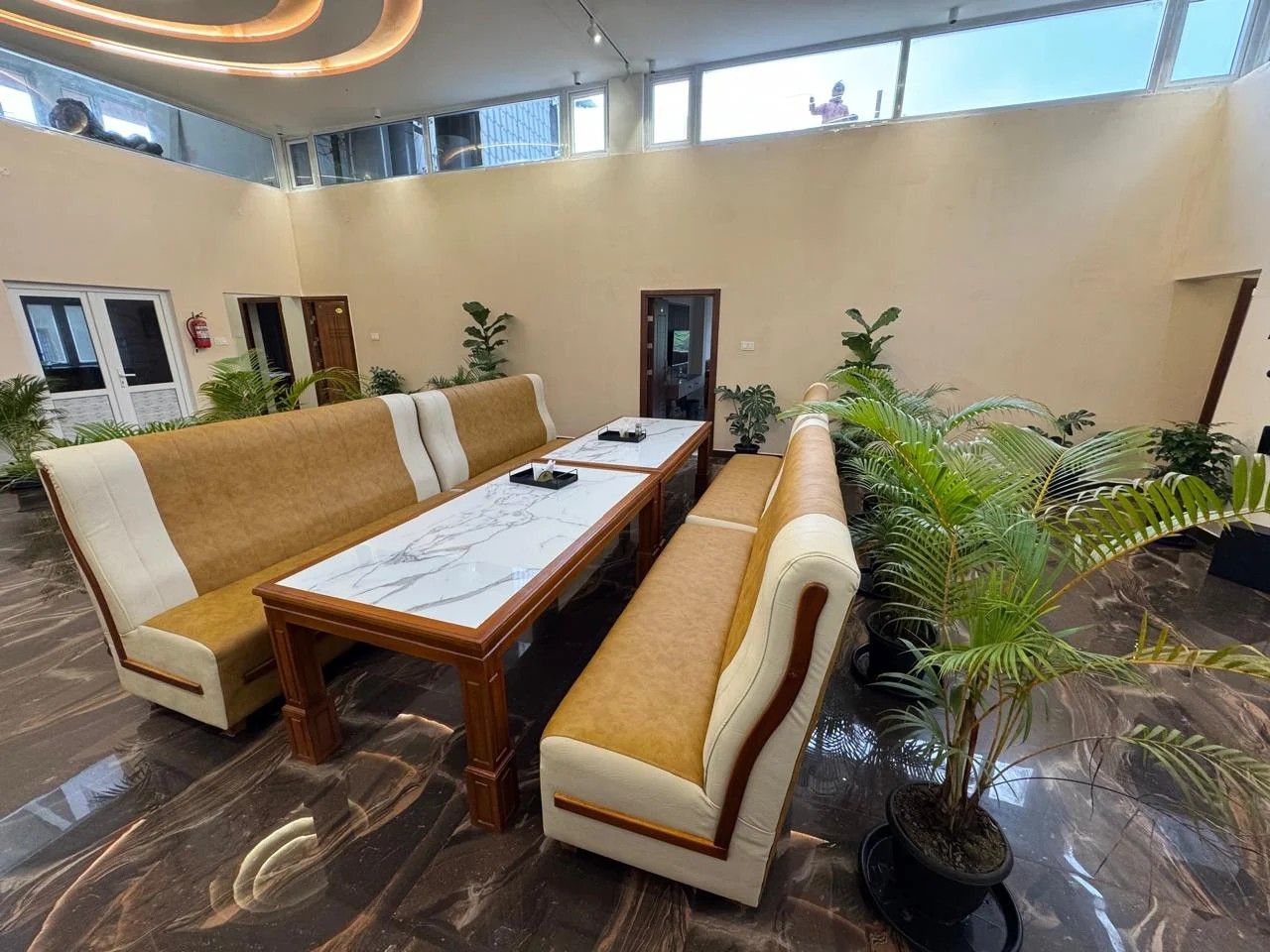 Lounge seating with marble-top table surrounded by palms