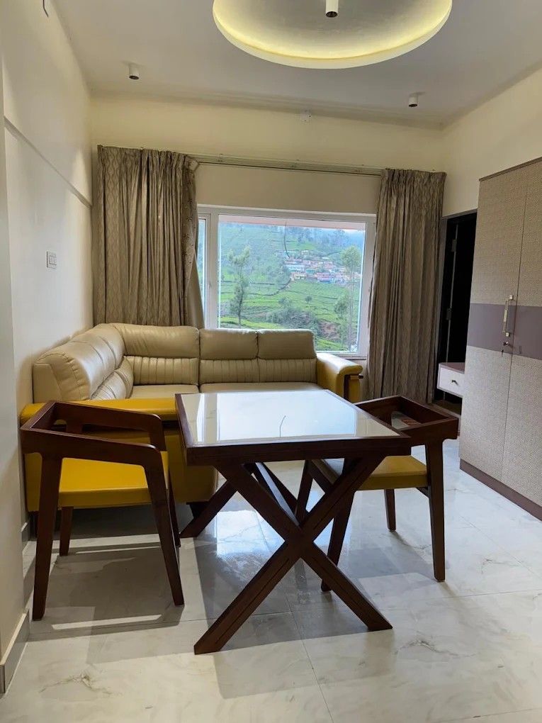Suite living area with sofa and dining table beside a tea-garden window
